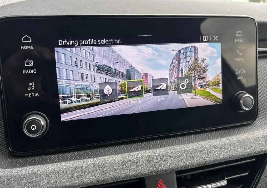 Écran tactile central de la Skoda Scala TSI 116 blanc, affichant les modes de conduite en intérieur.