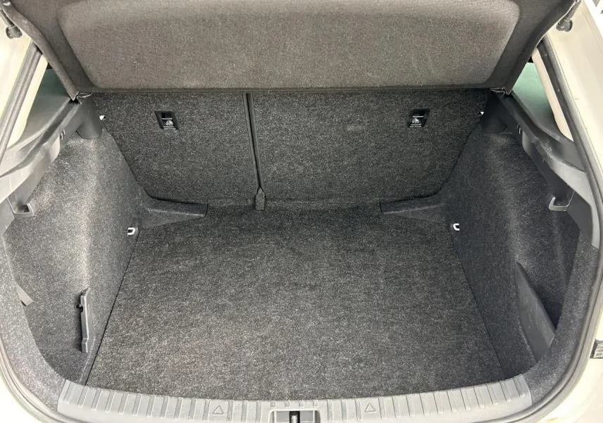 Coffre ouvert vu de l'arrière d'une Skoda Scala blanc Candy, montrant l'espace de chargement vide et tapissé.