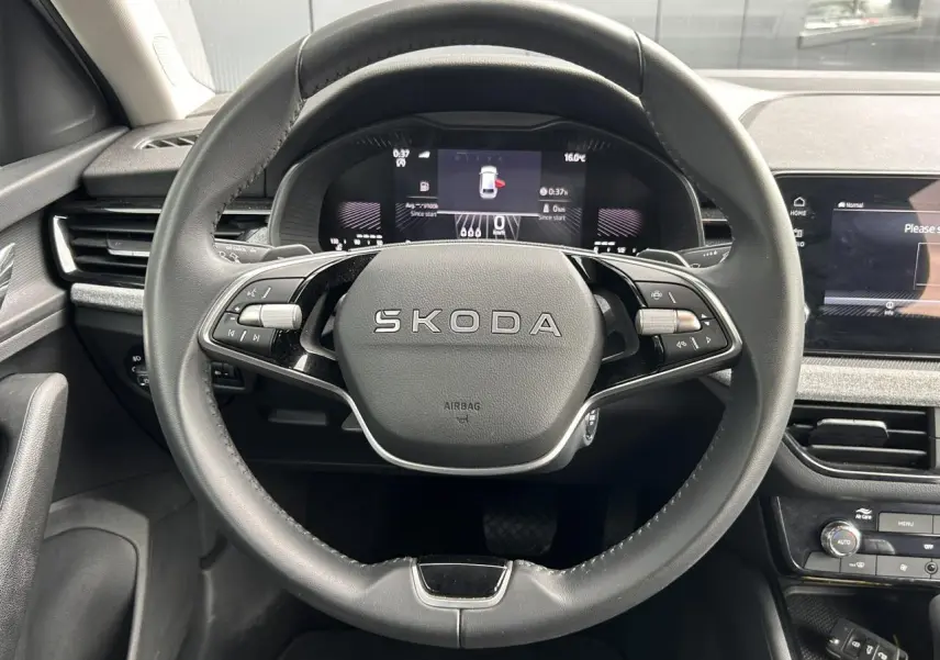 Vue frontale du volant noir multifonctions de la Skoda Scala 2025 avec tableau de bord digital et écran tactile à droite.