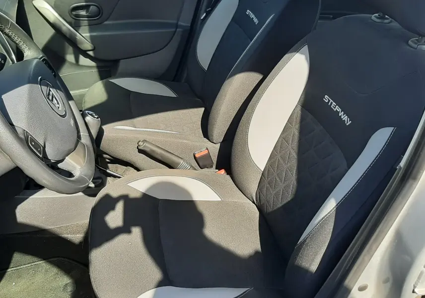 Vue intérieure côté conducteur de la Dacia Sandero Stepway 2016, sièges tissu gris noir avec logo Stepway brodé.