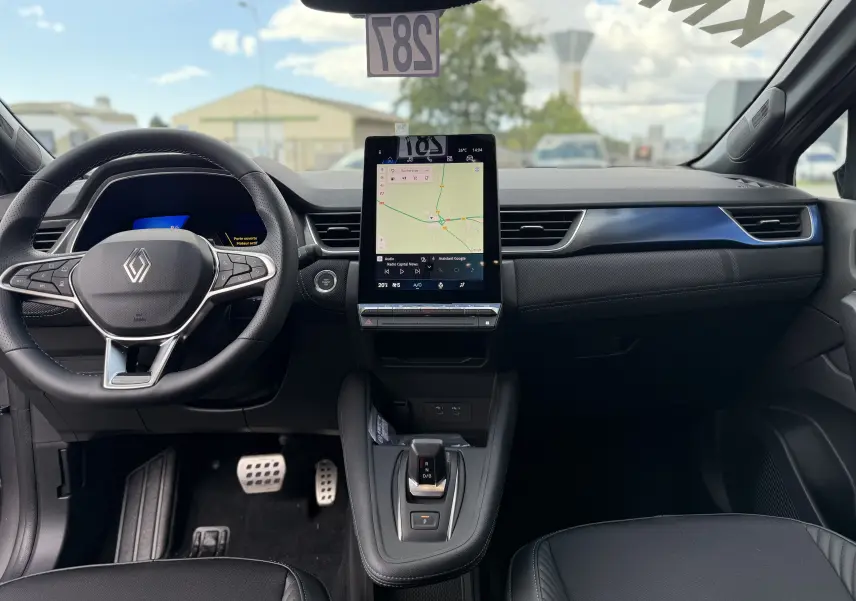 Vue intérieure frontale du tableau de bord du Renault Symbioz gris cassiopée, avec écran tactile central et volant multifonction.