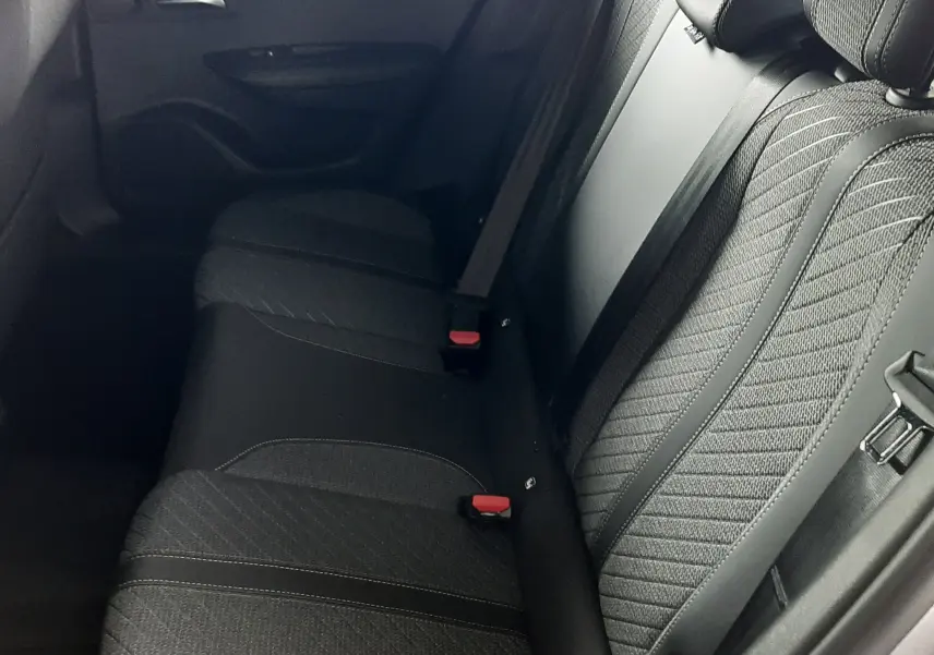Vue latérale droite de la banquette arrière en tissu noir avec ceinture de sécurité, intérieur du Peugeot 2008 gris Artense.