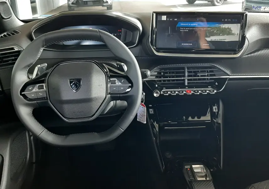 Intérieur noir du Peugeot 2008 1.2 Hybrid 145ch Allure 2025, vue frontale sur le volant et l'écran tactile central.