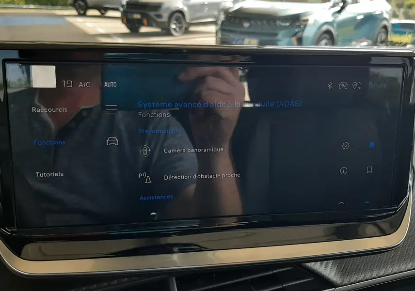 Écran tactile du système d’aide à la conduite dans un Peugeot 2008 gris Artense, vue intérieure frontale.