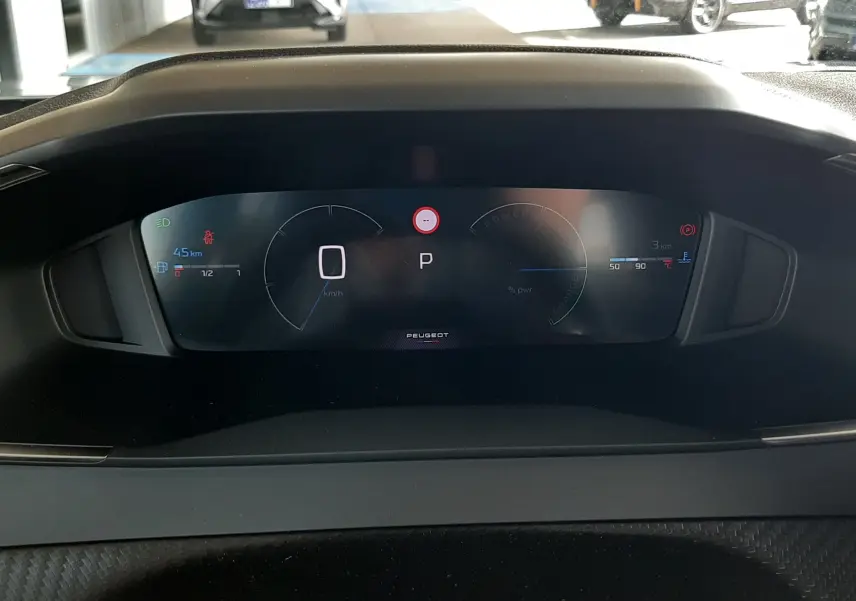 Vue rapprochée du tableau de bord numérique du Peugeot 2008 gris Artense, affichant la vitesse à zéro et la position parking.
