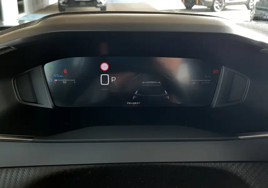 Vue rapprochée du tableau de bord numérique du Peugeot 2008 gris Artense, affichant la vitesse et l'état du véhicule.