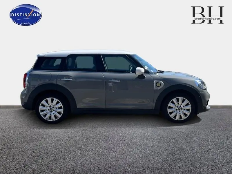 Profil droit d'une MINI Countryman Cooper SE Moonwalk Grey avec toit et rétroviseurs blancs, jantes alu 18 pouces design Pin Spoke.