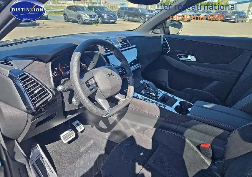 Intérieur avant du DS7 1.5 BlueHDi 130 Pallas 2025 avec volant cuir, console centrale brillante et sièges noirs en tissu et cuir.