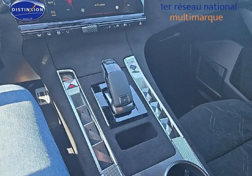 Vue rapprochée de la console centrale du DS7 gris titane 2025, avec levier de vitesse et boutons en chrome.