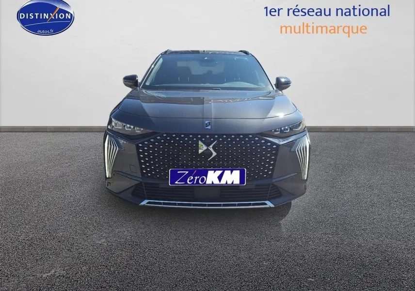 Vue frontale du DS7 gris titane 2025 avec calandre distinctive et feux LED verticaux allumés.