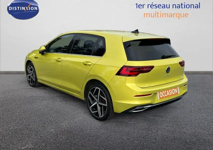 Vue 3/4 arrière droite d'une Volkswagen Golf jaune vif avec jantes alliage et vitres teintées.