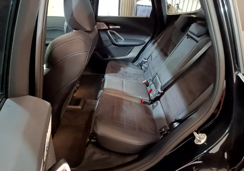 Vue intérieure côté droit montrant la banquette arrière en cuir noir du BMW X1 xDrive23i M Sport 2023.