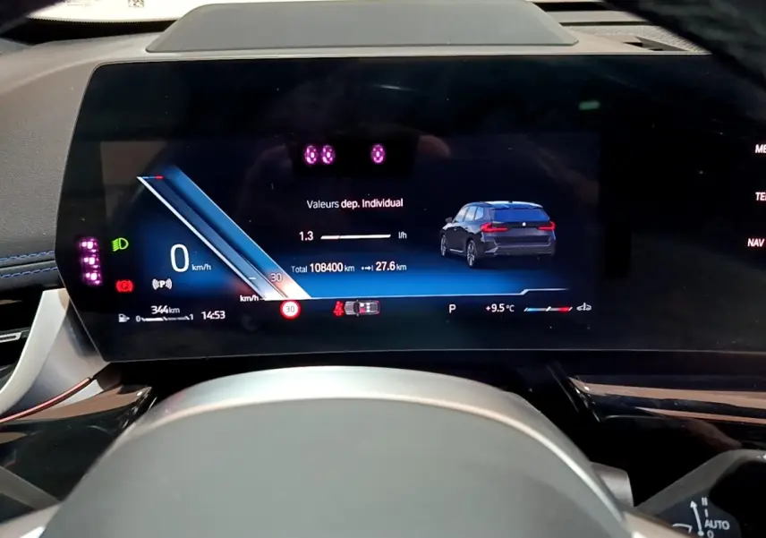 Vue rapprochée du tableau de bord numérique du BMW X1 noir 2023 affichant vitesse, autonomie et indicateurs.