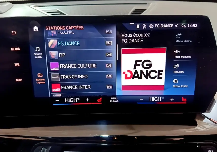 Écran tactile central du tableau de bord BMW X1 noir 2023 affichant la radio FG.DANCE et commandes climatisation.