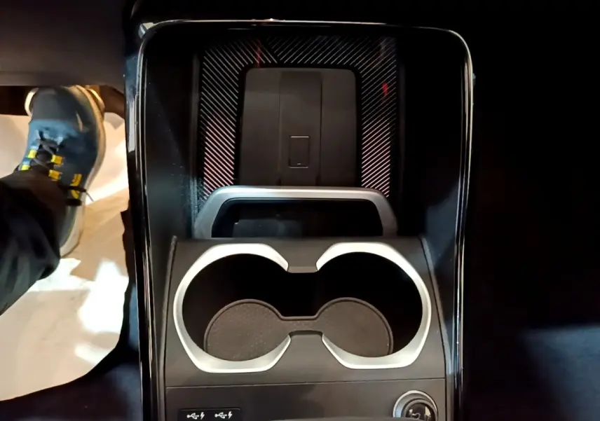 Vue plongeante sur la console centrale noire du BMW X1 xDrive23i M Sport avec porte-gobelets et ports USB-C.