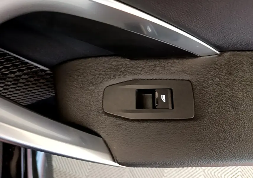Détail de la commande de lève-vitre sur la porte intérieure en cuir noir du BMW X1 xDrive23i M Sport 2023.