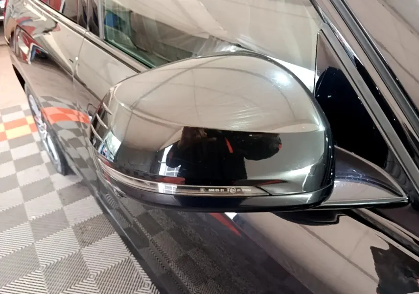 Rétroviseur côté conducteur noir brillant de BMW X1 xDrive23i M Sport 2023, vue rapprochée sur la portière noire.