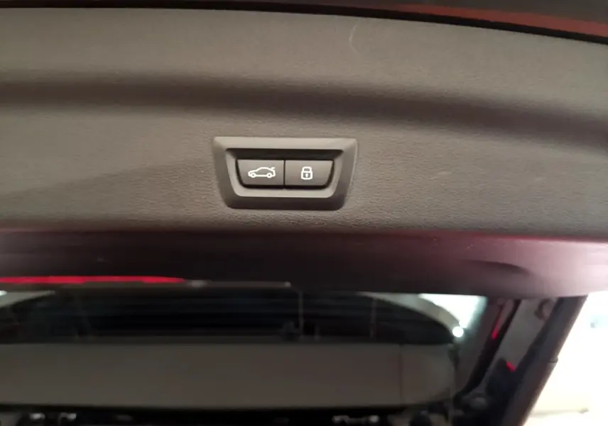 Boutons de fermeture et verrouillage du coffre vus de l'intérieur du hayon du BMW X1 noir xDrive23i M Sport 2023.