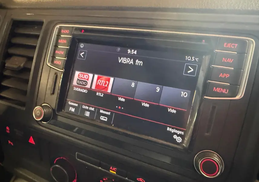 Vue rapprochée de l’écran multimédia du Volkswagen Transporter 2019 avec affichage de stations radio et commandes tactiles.