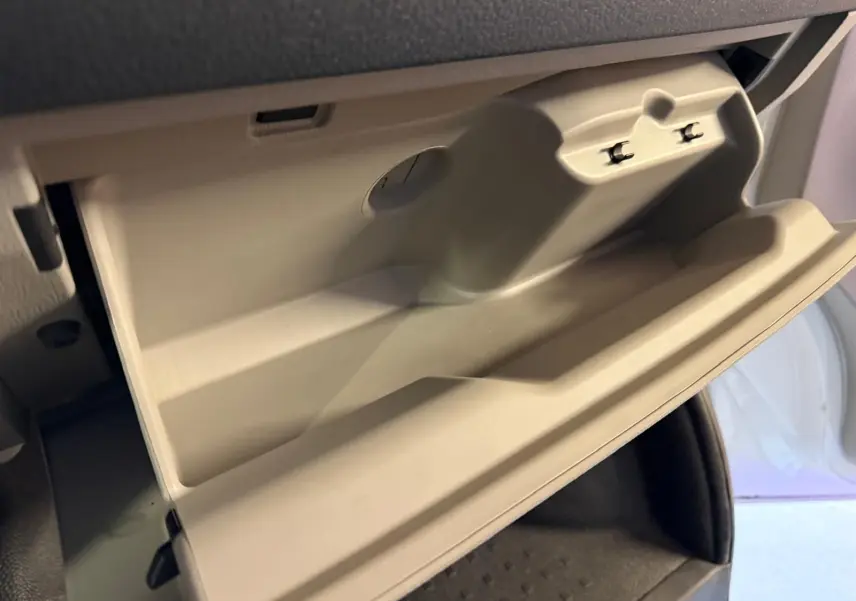 Vue rapprochée de la boîte à gants beige ouverte dans l'habitacle du Volkswagen Transporter blanc 2019.