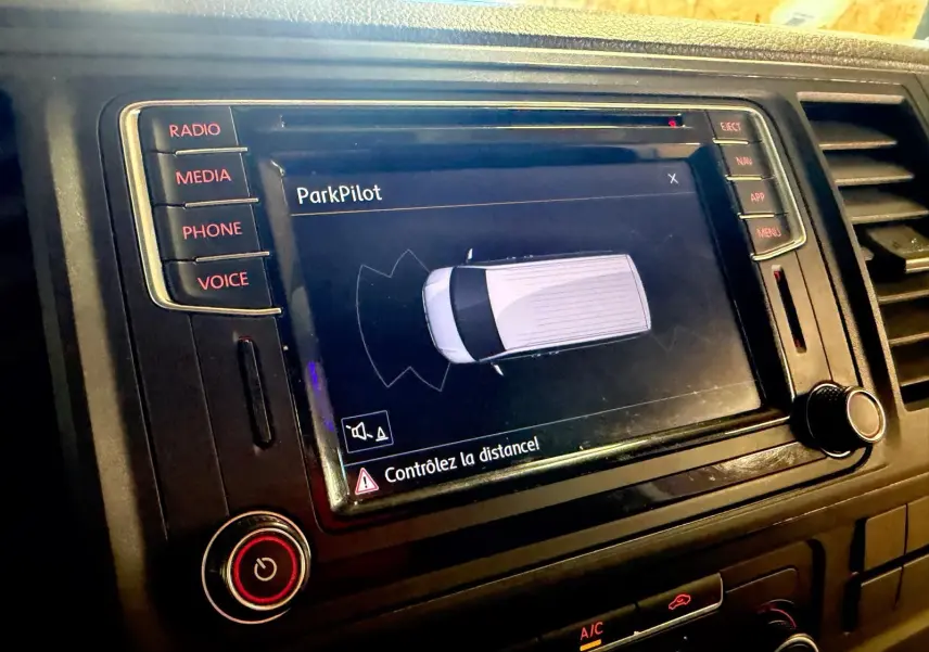 Vue rapprochée de l’écran central du Volkswagen Transporter blanc 2019 affichant l’interface ParkPilot.