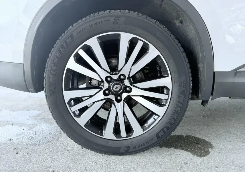 Gros plan sur la roue avant droite blanche d’un Renault Koleos 2021 avec jante alliage bicolore et pneu Michelin.