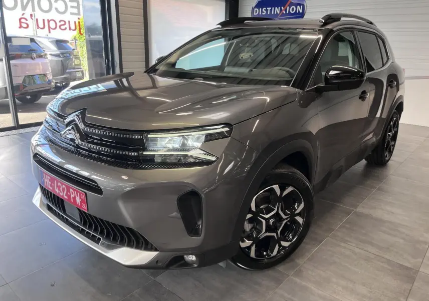 Vue 3/4 avant droit du Citroën C5 Aircross gris platinium avec jantes bi-ton et calandre noire brillante.