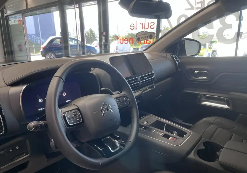Vue intérieure côté conducteur du Citroën C5 Aircross gris, avec volant cuir et écran tactile central.