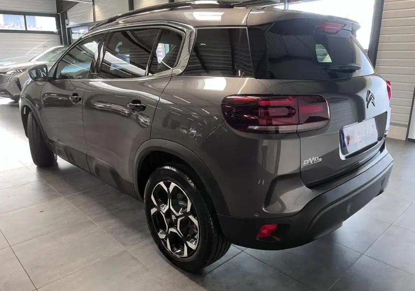 Vue 3/4 arrière droite du Citroën C5 Aircross gris platinium avec jantes alliage bi-ton et vitres surteintées.