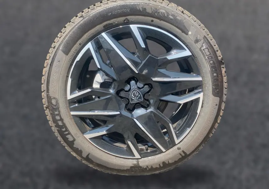 Gros plan sur une jante alu noire et grise de Peugeot 3008 1.2 hybrid 145 allure business, avec pneu Michelin.