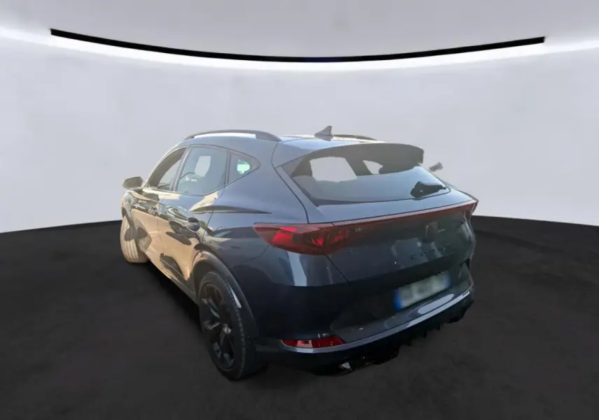 Vue 3/4 arrière droite du CUPRA Formentor gris avec jantes alliage noires et bandeau lumineux arrière LED.