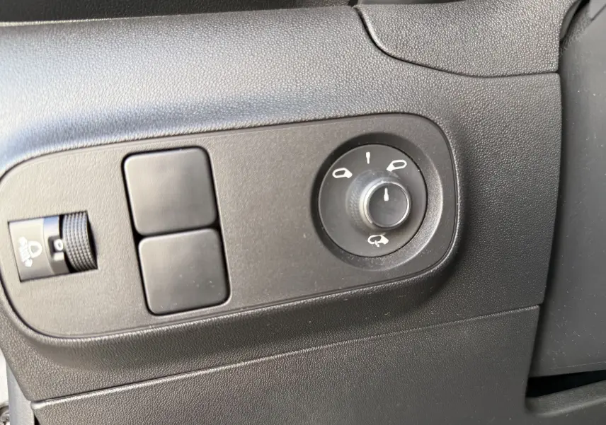 Gros plan sur les commandes de réglage des rétroviseurs et de l'éclairage intérieur d'une Citroën C3 gris acier 2023.