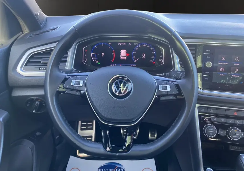 Vue rapprochée du volant noir et du tableau de bord numérique du Volkswagen T-Roc 2.0 TDI 2021, intérieur moderne.