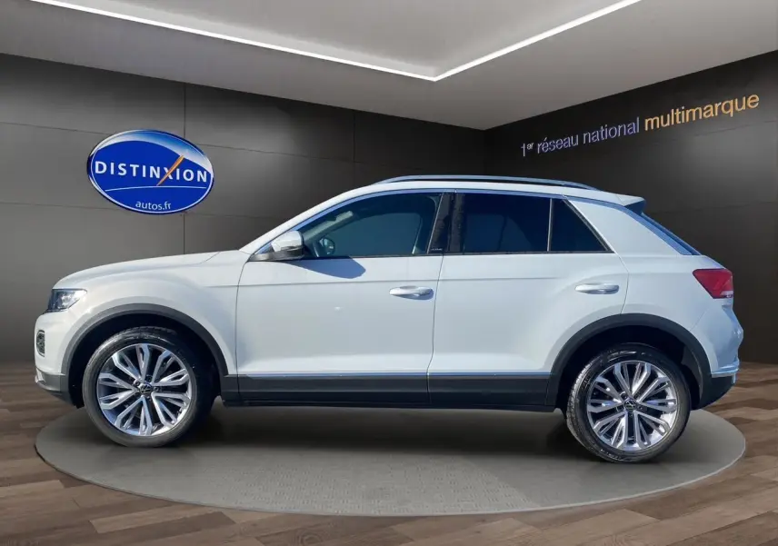 Profil latéral droit du Volkswagen T-Roc 2021 en blanc argenté avec jantes alu 18 pouces et toit ouvrant panoramique.