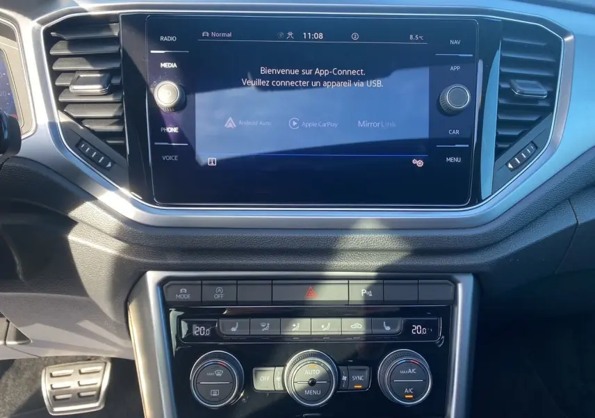 Vue rapprochée du tableau de bord noir du Volkswagen T-Roc 2021 avec écran tactile et commandes de climatisation.