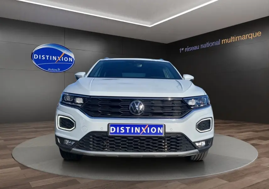 Vue frontale d'un Volkswagen T-Roc 2.0 TDI blanc argenté avec calandre noire et feux LED distinctifs.