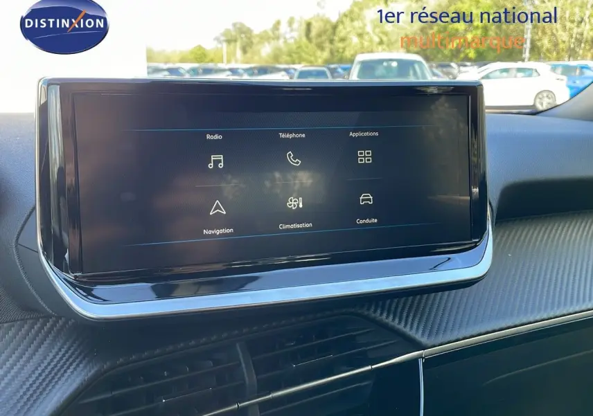 Écran tactile central du tableau de bord de la Peugeot 2008 2024, avec interface affichant radio, téléphone et navigation.