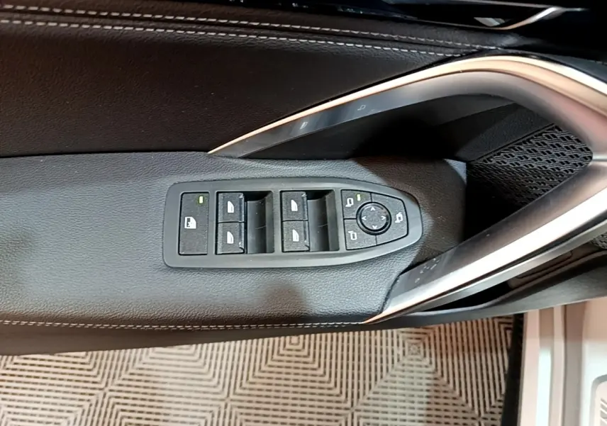 Commande des vitres et rétroviseurs sur la porte côté conducteur d’un BMW X1 gris clair xDrive23i M Sport 2023.