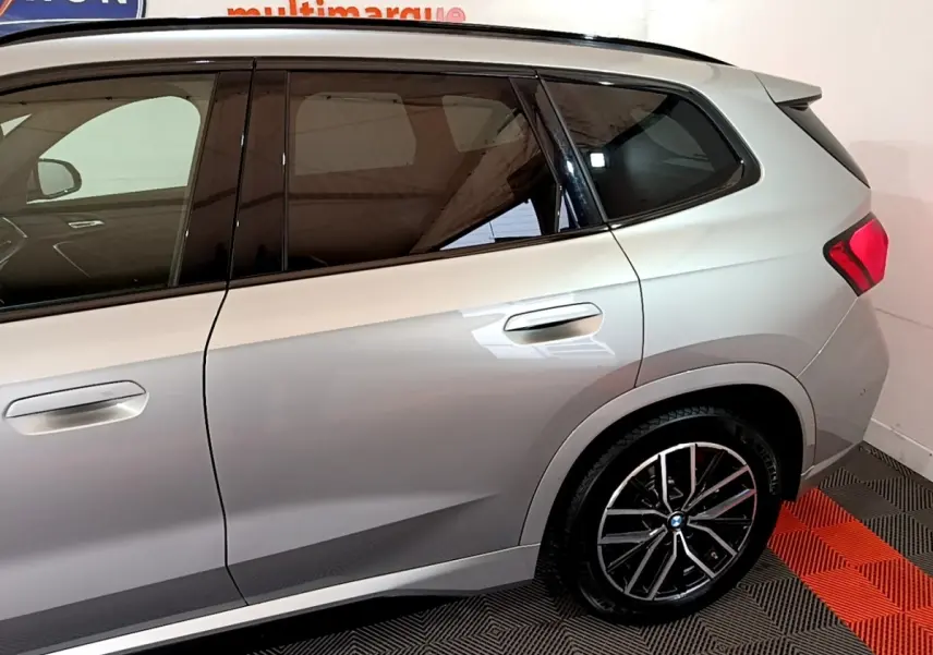 Vue latérale droite du BMW X1 xDrive23i M Sport gris clair, mettant en valeur les jantes alliage et les vitres teintées.