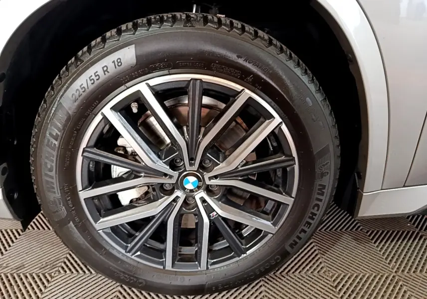 Gros plan sur la roue avant droite gris clair du BMW X1 xDrive23i M Sport avec jante alliage noir et argent.