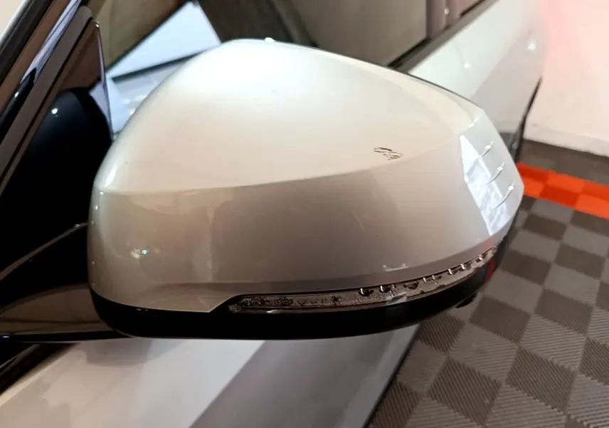 Gros plan sur le rétroviseur droit gris clair du BMW X1 xDrive23i M Sport avec clignotant intégré.