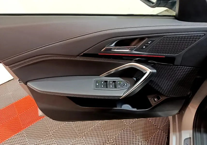 Vue intérieure du panneau de porte côté conducteur gris clair de BMW X1 xDrive23i M Sport 2023 avec commandes électriques et insert décoratif noir.