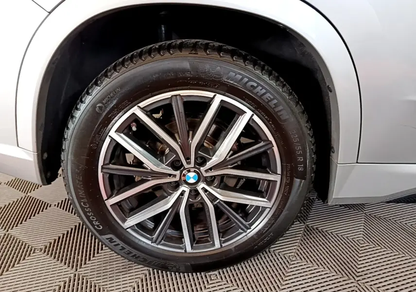 Gros plan sur la roue avant droite gris clair d’un BMW X1 xDrive23i M Sport 2023 avec jante alliage et pneu Michelin.