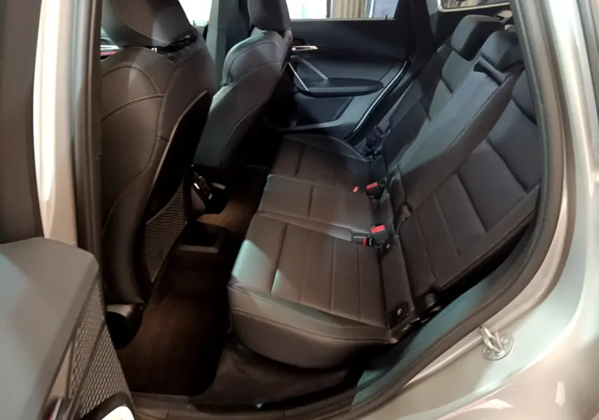 Vue intérieure côté droit montrant la banquette arrière en cuir noir du BMW X1 xDrive23i M Sport gris clair 2023.
