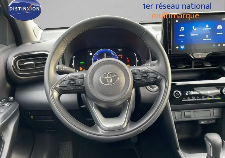 Vue intérieure centrée sur le volant cuir noir et le tableau de bord numérique de la Toyota Yaris Cross 2024.
