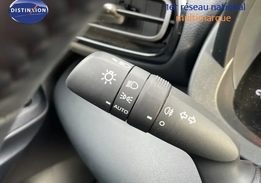 Gros plan sur la commande des phares et clignotants dans l’habitacle d’une Toyota Yaris Cross blanc pur 2024.