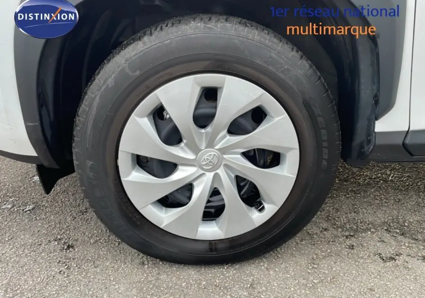 Gros plan sur la roue avant gauche blanche d'une Toyota Yaris Cross 2024 avec jante en plastique gris clair.