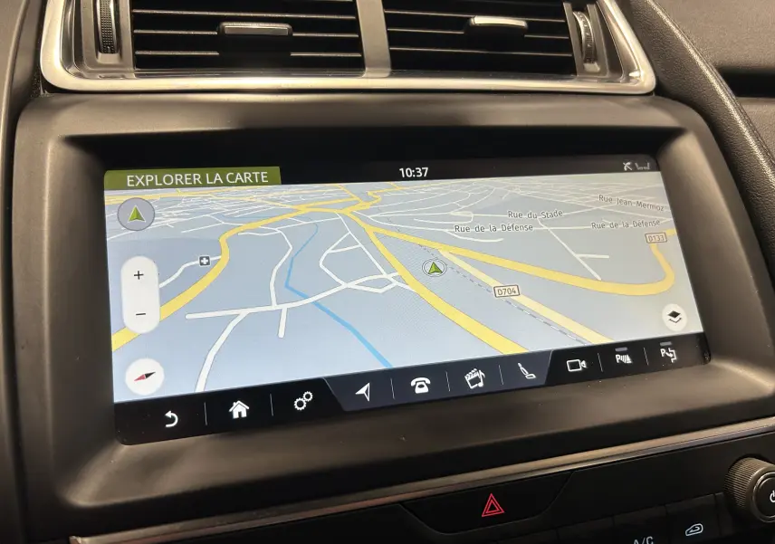 Écran tactile du GPS de la Jaguar E-PACE beige, affichant une carte routière avec options de navigation.