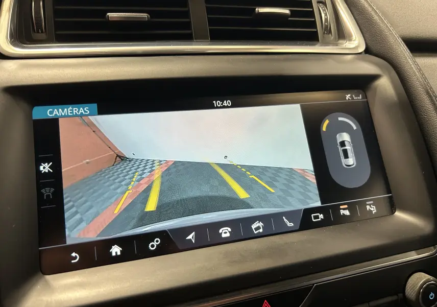 Écran intérieur de Jaguar E-PACE 2018 affichant la caméra de recul avec lignes de guidage jaunes et vue arrière du véhicule.
