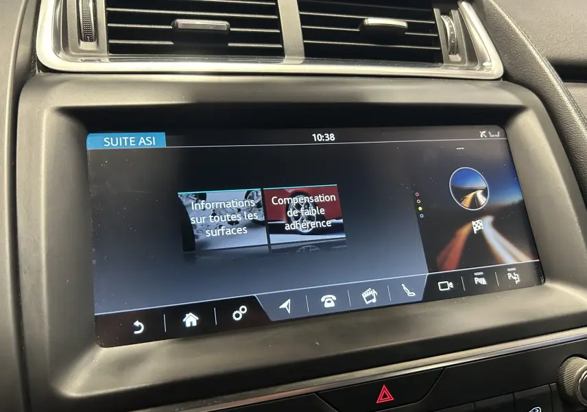 Gros plan sur l'écran tactile central du Jaguar E-PACE beige, affichant les options d'aide à la conduite.